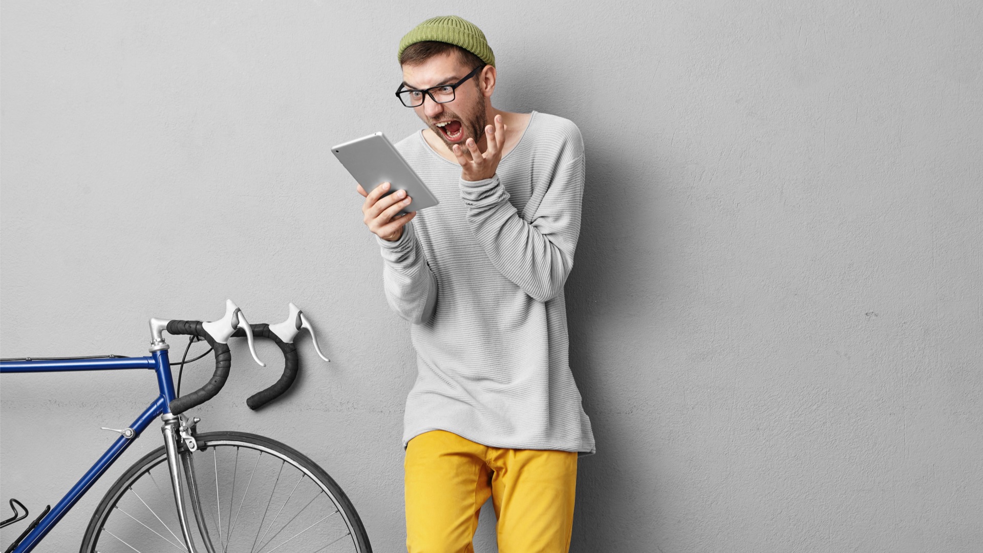 Cyclist reacts with surprise while looking at cycling performance data on a tablet.