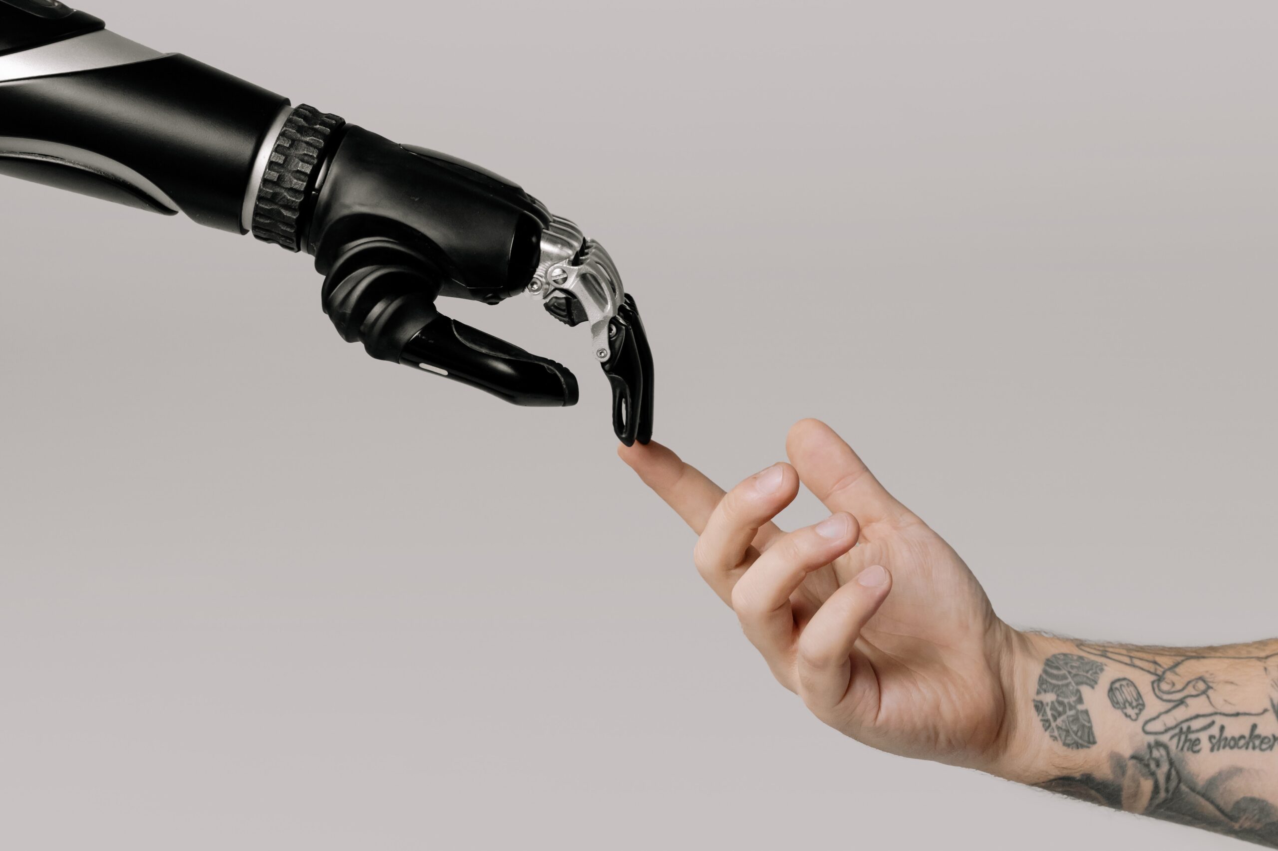 Robot hand touching human fingertip, showcasing collaboration between AI and human in cycling training, something generic cycling training plans can't offer.